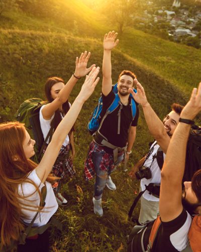 High,Angle,Of,Team,Of,Happy,Young,Tourists,Reaching,Out Schools